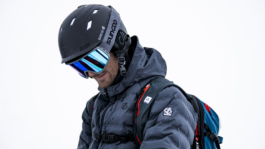 close up of male skier looking down towards his hands which are out of frame, wearing backpack Ross Woodhall - Action & Lifestyle Photography