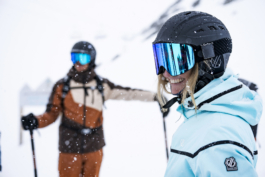 Woman skier looking out with male skier in background Ross Woodhall - Action & Lifestyle Photography