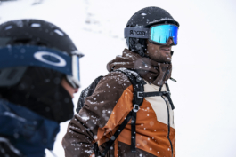 photographer focused on male skier with backpack on, helmet and googles with snow falling. Another skier closer, out of focus Ross Woodhall - Action & Lifestyle Photography